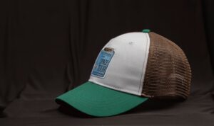 A stylish vintage baseball cap with green peak and mesh detailing, featuring a Space Tour patch.
